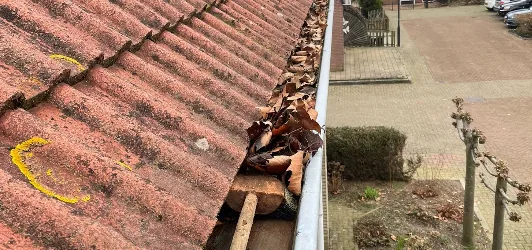 Dakgoot schoonmaken in Apeldoorn: goot vol bladeren en mos voor de reiniging Dakgoot schoonmaken in Apeldoorn: goot vol bladeren en mos voor de reiniging