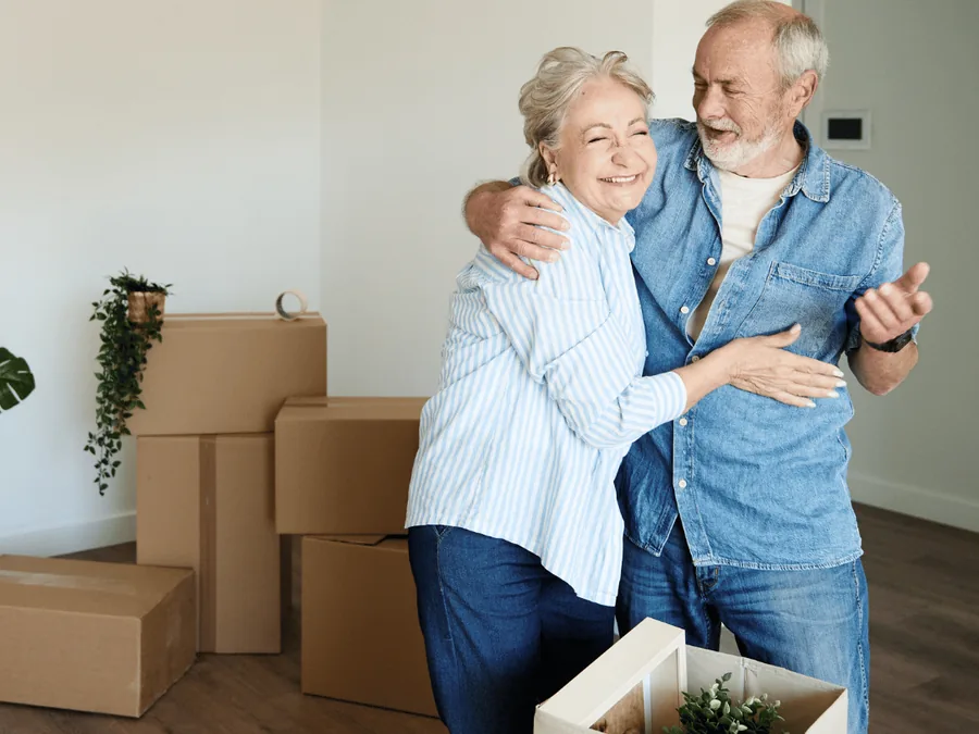Seniorenwoning ontruimen: ouder echtpaar tussen de verhuisdozen bij de overstap naar kleiner wonen Seniorenwoning ontruimen: ouder echtpaar tussen de verhuisdozen bij de overstap naar kleiner wonen
