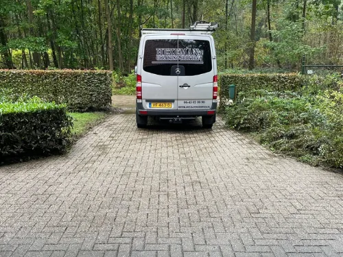 Woningontruiming Epe: de bus van Hezeman op de oprit van een woning tussen het groen