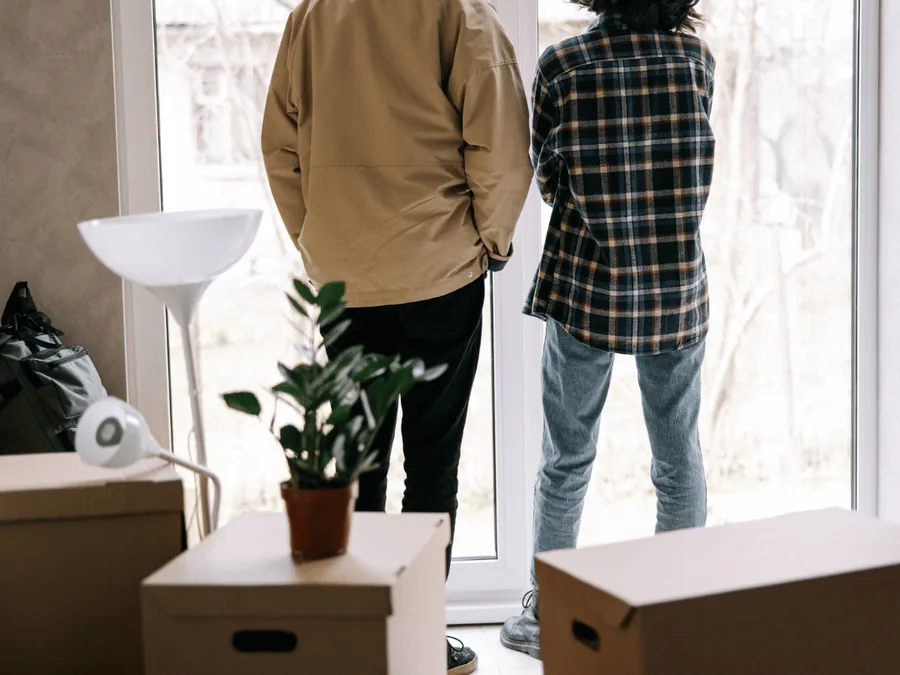 Woningontruiming Zwolle: twee bewoners bij het raam tussen de verhuisdozen